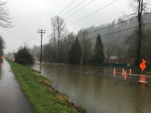View from the Cedar River Trail of the I-169 and the Cedar River. It is raining and the road is flooded.