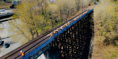 People in reflective gear walk in a wooden trestle