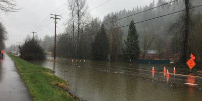 View from the Cedar River Trail of the I-169 and the Cedar River. It is raining and the road is flooded.