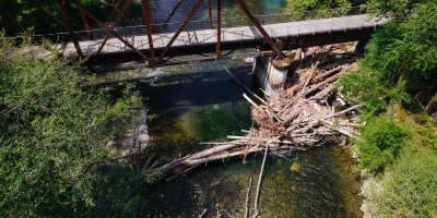 Aerial photo of river with a steel bridge and large woody debris